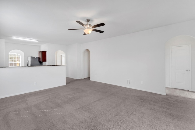 unfurnished living room featuring carpet and ceiling fan