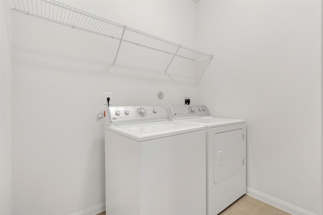 clothes washing area with light tile patterned floors and washing machine and dryer