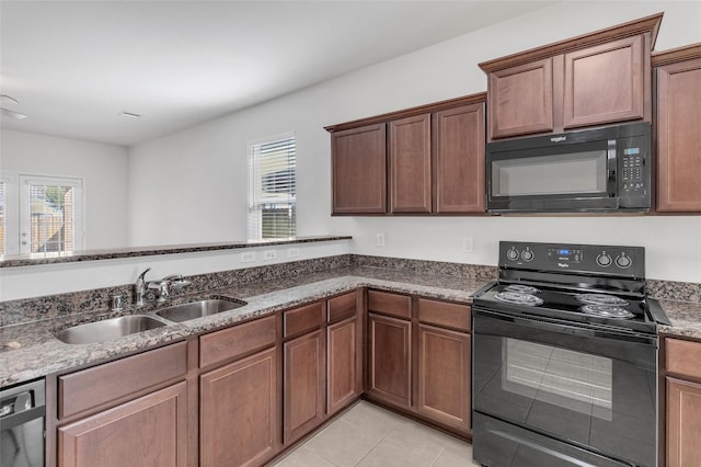 kitchen with black appliances, plenty of natural light, light tile patterned floors, and sink