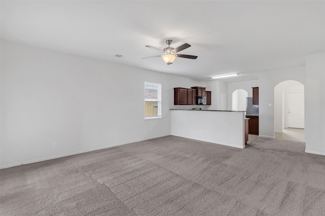 unfurnished living room with light carpet and ceiling fan