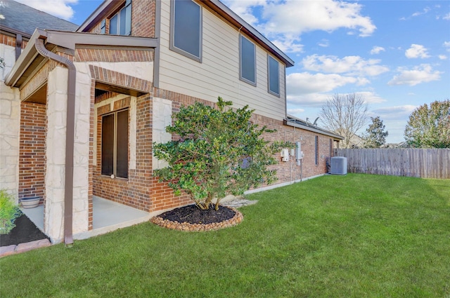 view of side of home with a yard, a patio, and cooling unit