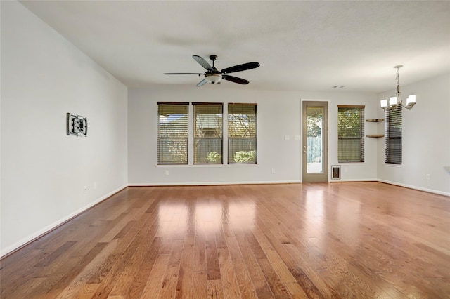 unfurnished room featuring hardwood / wood-style floors and ceiling fan with notable chandelier