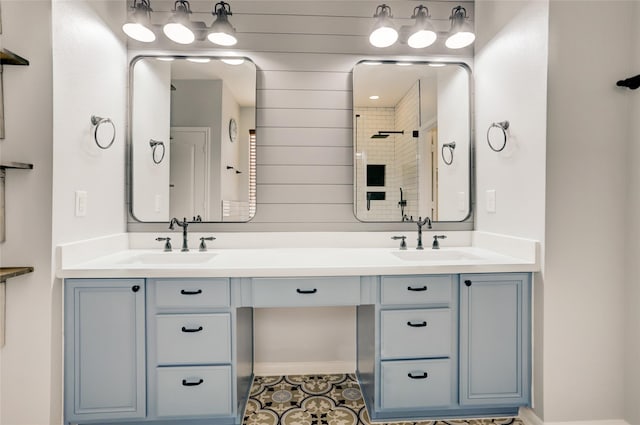 bathroom featuring tile patterned flooring, a tile shower, vanity, and wood walls