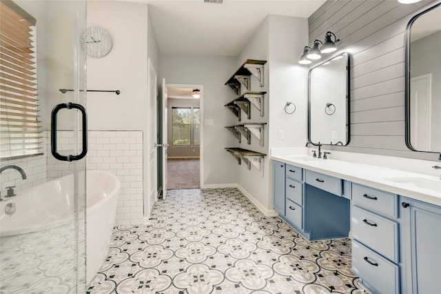 bathroom featuring a washtub, vanity, ceiling fan, and wood walls