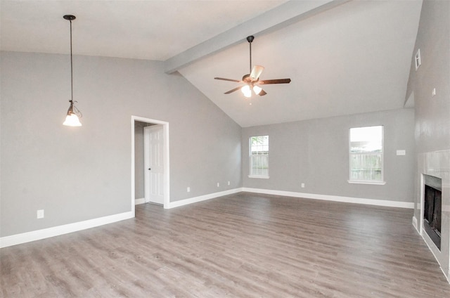 unfurnished living room with beam ceiling, ceiling fan, high vaulted ceiling, wood-type flooring, and a fireplace