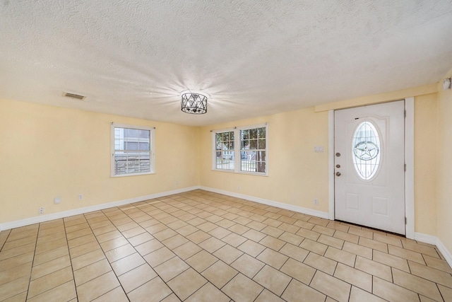 tiled entrance foyer featuring plenty of natural light and a textured ceiling