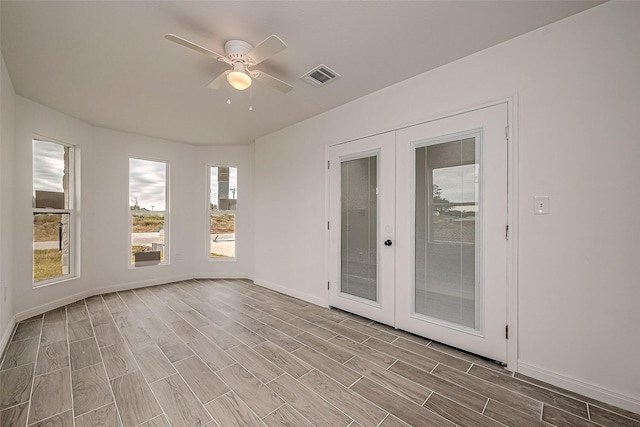 unfurnished sunroom featuring ceiling fan and french doors