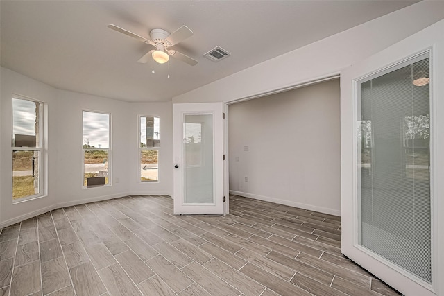 unfurnished sunroom featuring ceiling fan and french doors