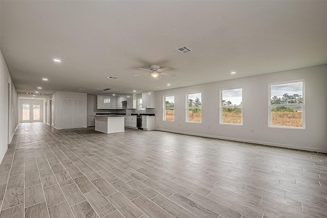 unfurnished living room with ceiling fan and plenty of natural light