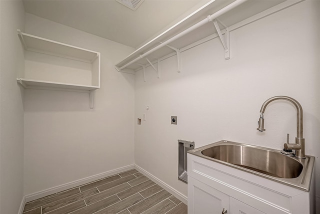 clothes washing area featuring hookup for an electric dryer, cabinets, and sink