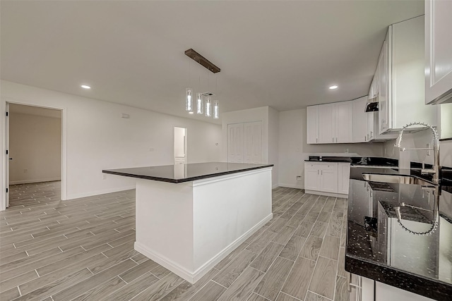 kitchen with white cabinets, hanging light fixtures, and a kitchen island