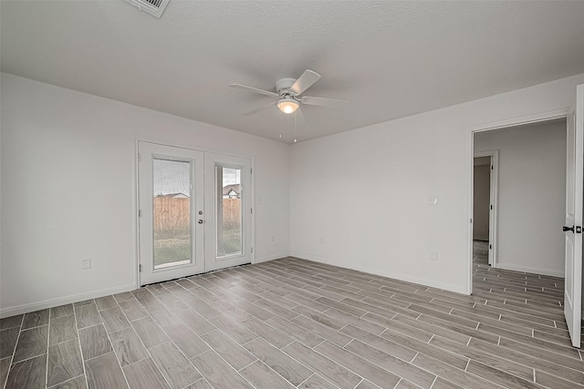 spare room featuring french doors, a textured ceiling, light hardwood / wood-style floors, and ceiling fan