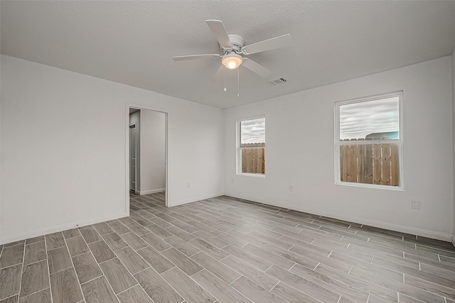 spare room featuring a textured ceiling, light hardwood / wood-style flooring, and ceiling fan