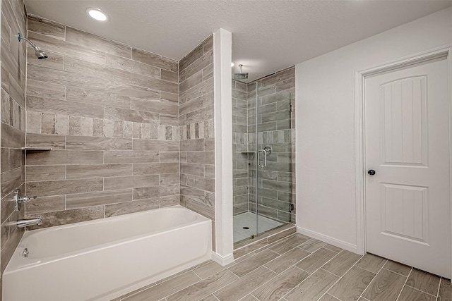 bathroom with separate shower and tub and a textured ceiling