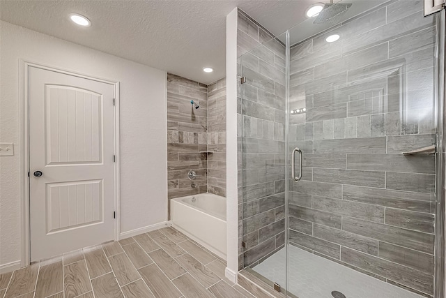 bathroom featuring a textured ceiling and shower with separate bathtub