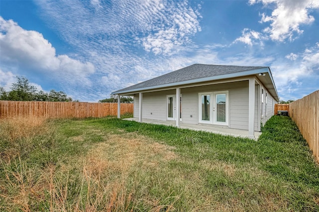 back of property featuring french doors and a lawn