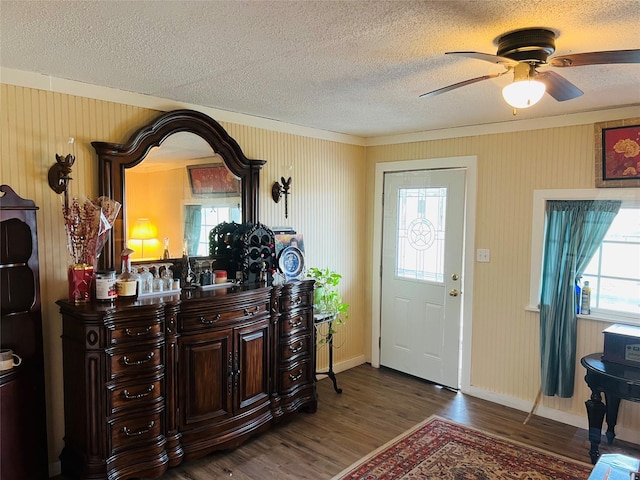 entryway with a textured ceiling, crown molding, ceiling fan, and dark hardwood / wood-style floors