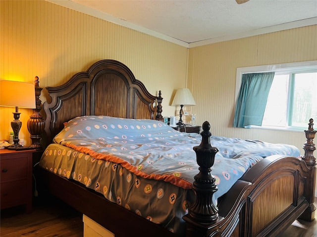 bedroom with dark hardwood / wood-style floors and a textured ceiling