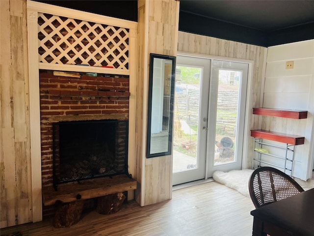 living room with hardwood / wood-style floors, a healthy amount of sunlight, and a brick fireplace