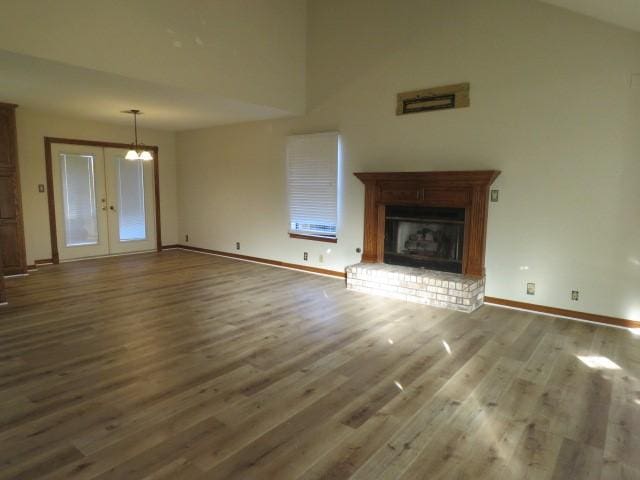 unfurnished living room featuring a fireplace, french doors, and hardwood / wood-style floors