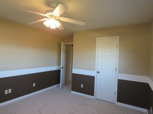 unfurnished bedroom featuring ceiling fan and light colored carpet