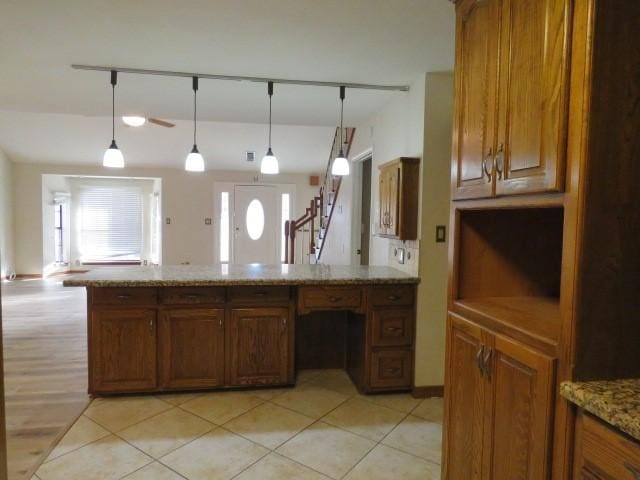 kitchen featuring light stone counters, light tile patterned floors, and hanging light fixtures