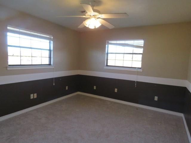 carpeted spare room with ceiling fan