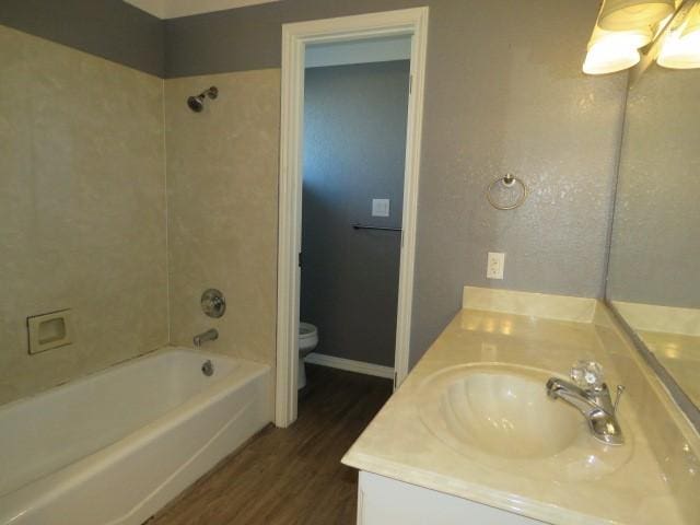 full bathroom with bathtub / shower combination, hardwood / wood-style floors, vanity, and toilet