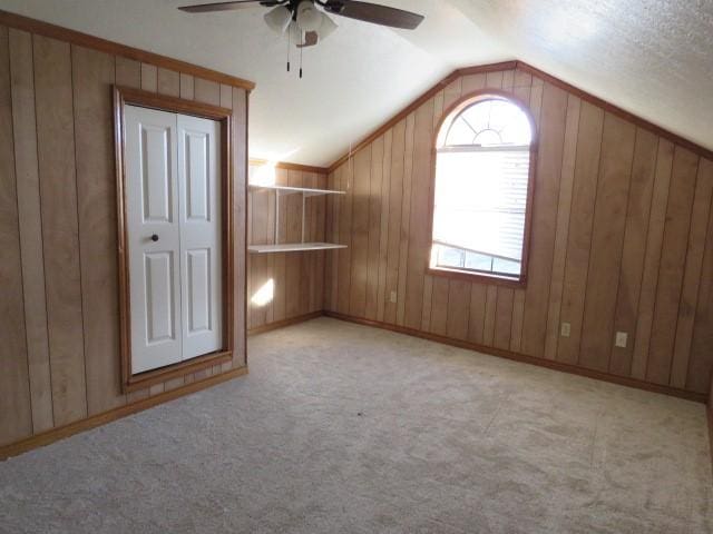 additional living space featuring ceiling fan, light colored carpet, and vaulted ceiling