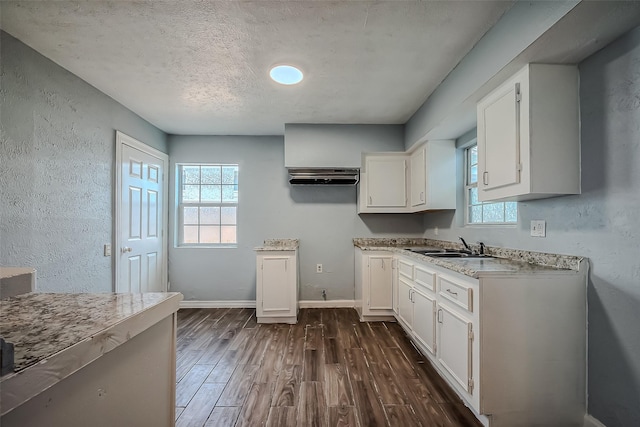 kitchen featuring sink, white cabinets, dark wood-type flooring, and a textured ceiling