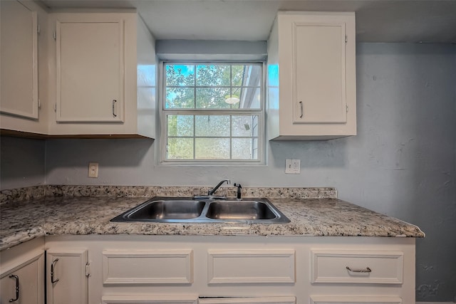 kitchen featuring white cabinetry and sink