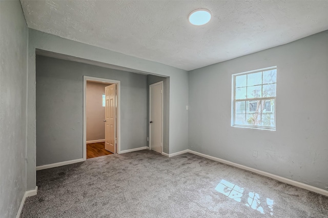 unfurnished bedroom with a closet, carpet, and a textured ceiling