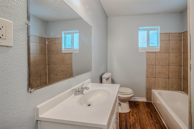 full bathroom featuring wood-type flooring, vanity, toilet, and tiled shower / bath combo