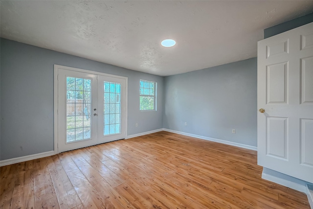 spare room featuring light wood-type flooring and french doors