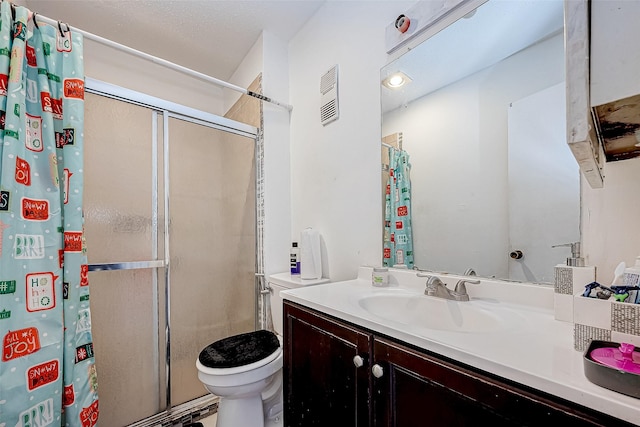 bathroom featuring vanity, toilet, and walk in shower