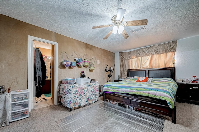 bedroom featuring ceiling fan, carpet floors, and a textured ceiling