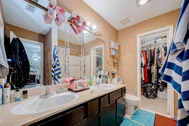 bathroom with vanity, a textured ceiling, and toilet