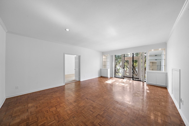 spare room featuring built in shelves, dark parquet flooring, and crown molding