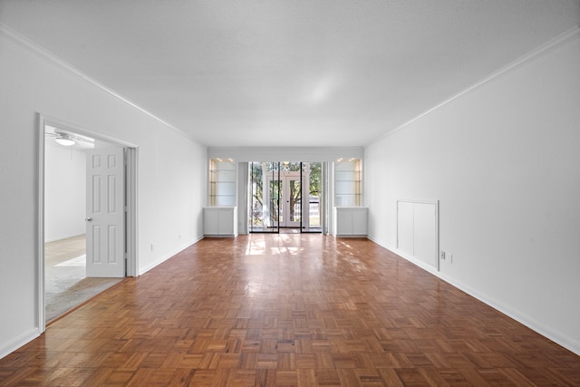 spare room featuring dark parquet floors, ceiling fan, built in features, and ornamental molding