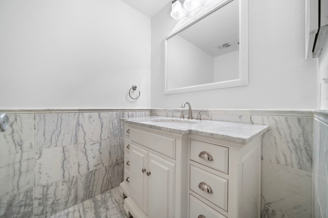 bathroom with vanity and tile walls