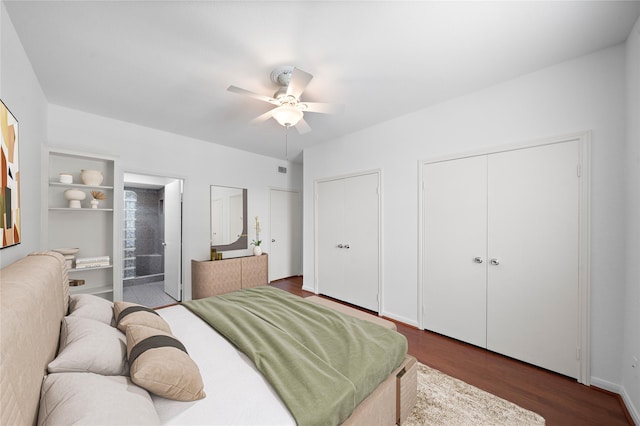 bedroom with connected bathroom, ceiling fan, dark hardwood / wood-style flooring, and multiple closets