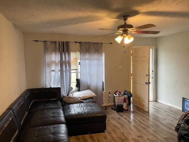 living room featuring ceiling fan, hardwood / wood-style floors, and a textured ceiling