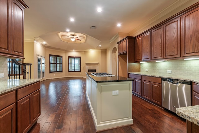 kitchen featuring ceiling fan, stainless steel appliances, dark stone counters, and dark hardwood / wood-style floors