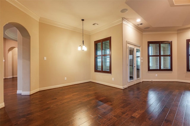 spare room featuring ornamental molding, dark hardwood / wood-style floors, and a notable chandelier