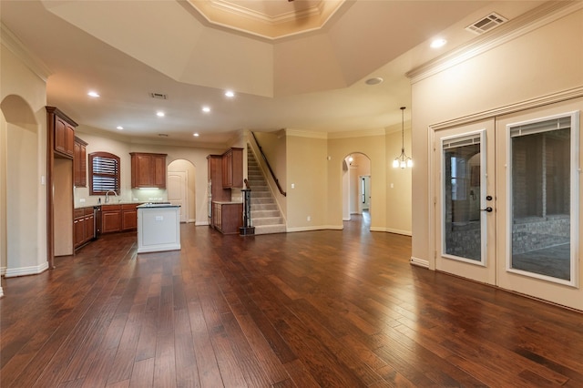 unfurnished living room featuring sink, ornamental molding, and dark hardwood / wood-style floors