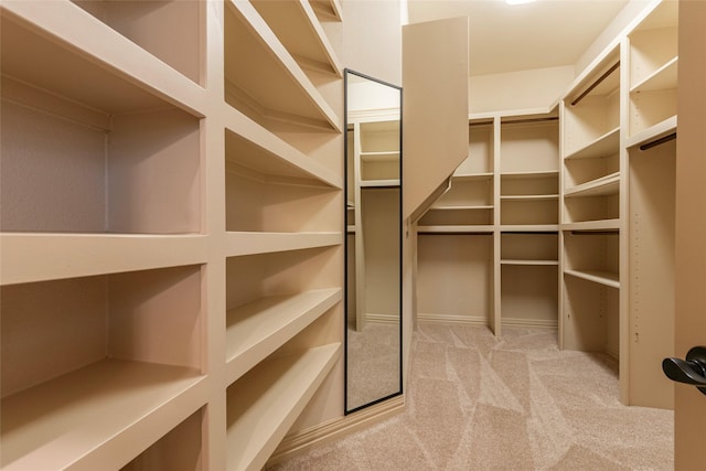 walk in closet with light carpet