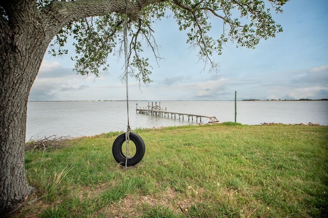 view of dock featuring a yard and a water view