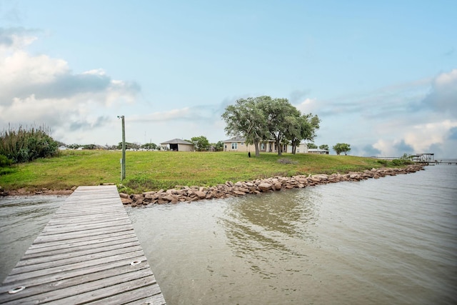 view of dock featuring a water view and a lawn