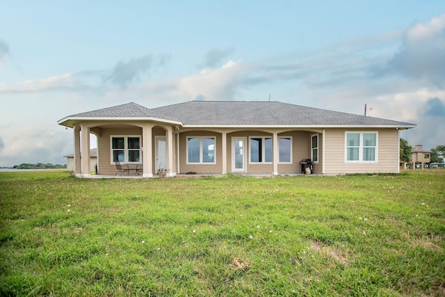 rear view of house featuring a lawn and a patio area