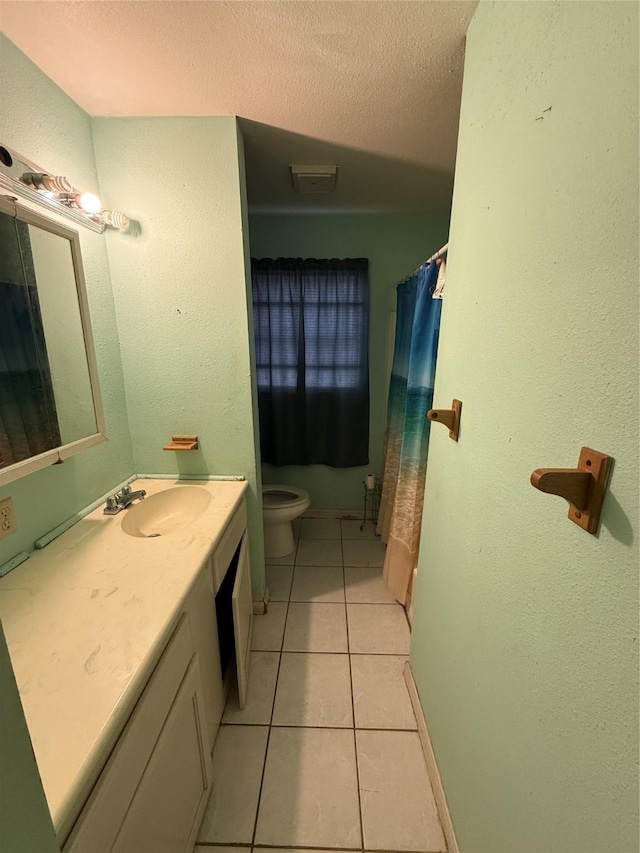 bathroom with a textured ceiling, toilet, vanity, and tile patterned flooring